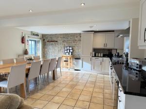 a kitchen and dining room with a table and chairs at Standlow Farm in Kniveton