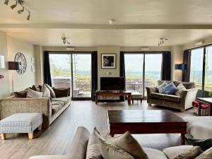 a large living room with couches and a tv at Standlow Farm in Kniveton