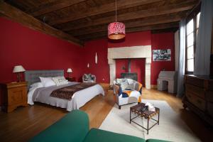 a bedroom with a bed and a red wall at Pont Vieux Chambres et Gites in Confolens