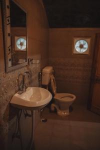 um banheiro com um vaso sanitário, uma pia e um espelho em Enthralling Escapes Nature Stay and Trek em Manali