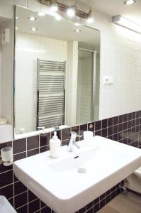 a bathroom with a white sink and a mirror at Apartment Jindrisska 25 in Prague