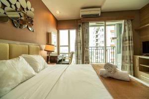 una camera da letto con un grande letto bianco e un balcone di 1BR Near GI Mall Thamrin SCBD2 a Giacarta Altre 48 foto