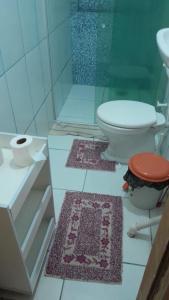 a bathroom with a toilet and a shower and two rugs at Casa aconchegante em Barra de Caravelas in Caravelas +48 photos