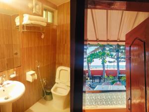 a bathroom with a toilet and a view of a beach at The Divine Eco Resort in Cox's Bazar