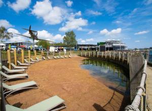 ein Flugzeug fliegt über einen Strand mit Liegestühlen in der Unterkunft Tattershall Lakes Luxury Hot Tub Breaks in Tattershall