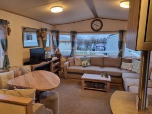 ein Wohnzimmer mit Sofa und Tisch in der Unterkunft Tattershall Lakes Luxury Hot Tub Breaks in Tattershall
