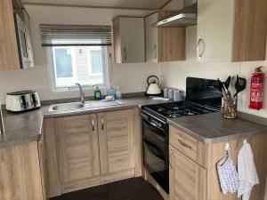 eine Küche mit Spüle und Herd oberen Backofen in der Unterkunft Tattershall Lakes Luxury Hot Tub Breaks in Tattershall