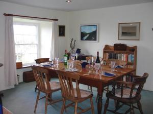 a dining room with a table with wine bottles and chairs at Roskear Farm in Wadebridge