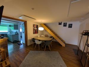 a living room with a table and a staircase at fewoflagmeier Meidelstetten I Maisonetten Wohnung Alb in Hohenstein