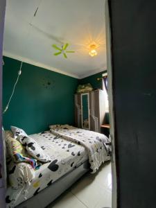 Tagalbatoにあるhomestay afdalのベッドと緑の壁のある寝室