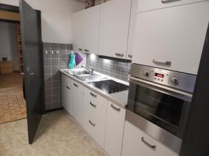a kitchen with white cabinets and a stainless steel oven at Ferienhaus Medebach in Medebach