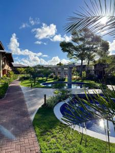 a resort with a swimming pool and a walkway at Itacimirim Bioflora - Térreo 2 Suítes in Itacimirim