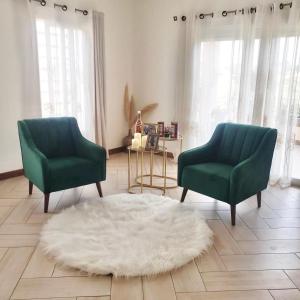two green chairs and a white rug in a living room at Tia Vahine - Navette Gratuite Aéroport H24 in Ivato +59 photos