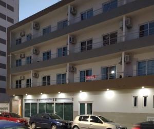 a large building with cars parked in front of it at Departamentos Casa de playa in Necochea