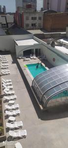 una fila de sillas y una piscina en un edificio en Casa de playa monoambiente, en Necochea