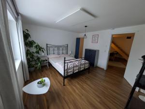 a bedroom with a bed and a table at fewoflagmeier Meidelstetten I Maisonetten Wohnung Alb in Hohenstein