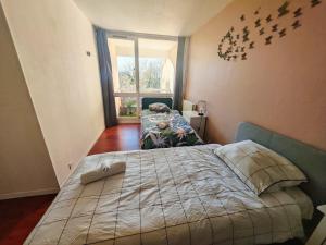 a bedroom with a bed with birds on the wall at T3 COSY petit balcon 5mins France miniature in Élancourt