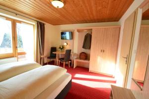 a hotel room with two beds and a table at Gästehaus Sonnenbichl in Fischbachau