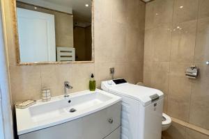 a bathroom with a sink and a toilet and a mirror at Cosy Cocoon Place Massena in Nice