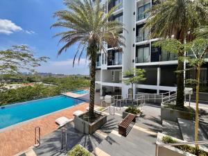 an apartment building with a swimming pool and palm trees at Gala City CornerApt Gala residence in Kuching