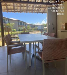 d'une table à manger et de chaises sur une terrasse avec vue. dans l'établissement Excelente em Itacimirim novo, à Camassari
