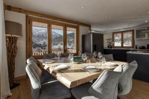 a dining room with a wooden table and chairs at Chalet Des Grands Vanays in Les Houches