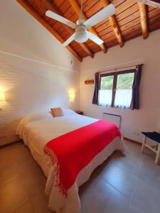 a bedroom with a large bed with a red blanket at Medanos in Las Gaviotas