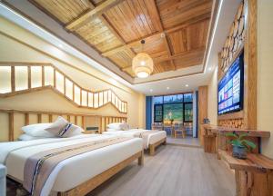 HanqiyuFenglin Woodhouse B&B in Wulingyuan District, Zhangjiajie的一间卧室设有三张床和一台平面电视
