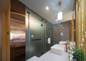 HanqiyuFenglin Woodhouse B&B in Wulingyuan District, Zhangjiajie的一间带水槽和卫生间的浴室 更多1张照片