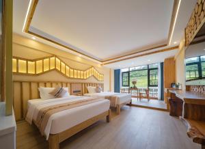HanqiyuFenglin Woodhouse B&B in Wulingyuan District, Zhangjiajie的有两张床和一张桌子的酒店房间