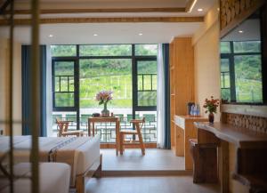 HanqiyuFenglin Woodhouse B&B in Wulingyuan District, Zhangjiajie的一间卧室配有一张床和一张桌子及椅子