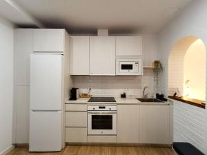 eine Küche mit weißen Schränken und einem weißen Kühlschrank in der Unterkunft Casita El Lagar in Estepona