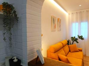 ein Wohnzimmer mit einem orangenen Sofa und einem Fenster in der Unterkunft Casita El Lagar in Estepona + 10 Fotos