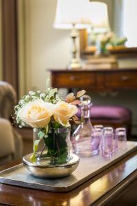 a vase filled with roses on a table at 1905 Boutique Hotel in Xanthi +59 photos