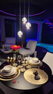 a dining table with plates and wine glasses on it at Suite de luxe érotique chic in Coursan