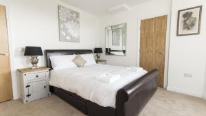 a bedroom with a large bed with white sheets at Captains Quarters 4 Apartment in Plymouth