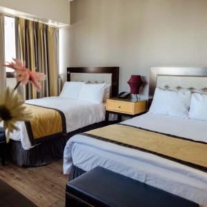a hotel room with two beds and a window at Stamford Suites in Stamford