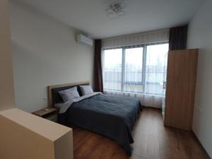 a bedroom with a bed and a large window at Pana Green Residence in Panagyurishte