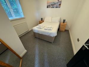 a small bedroom with a bed with towels on it at Saltram By Pureserviced in Plymouth