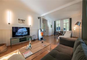 a living room with a couch and a tv at Chalet Hunnenfluh Garden Apartment in Wengen