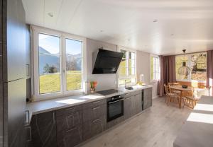 a kitchen with a sink and a tv on the wall at Chalet Hunnenfluh Garden Apartment in Wengen