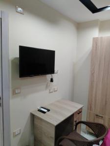 a room with a desk with a television on the wall at استديو فندقي لك لوحدك in 6th Of October