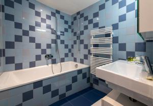 a blue and white bathroom with a tub and a sink at Panoramapark Soleil E 3 in Wengen +38 photos