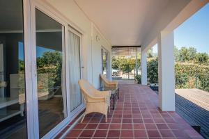 a porch with two chairs and glass doors at On Helderberg in Somerset West