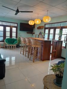 a kitchen with a bar with chairs and a table at Celon vie Beachfront Hotel Ahangama in Ahangama