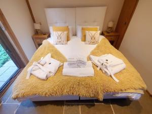 a bedroom with a bed with towels on it at Swn Y Nant Lodge with hot tub Brecon in Brecon