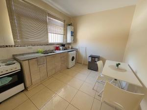 Una cocina con una mesa, un fregadero y una estufa. en casa Mitre, en San Juan 2 fotos más