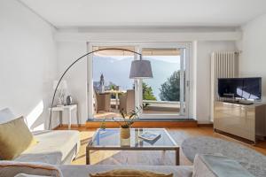 un soggiorno con un divano e un tavolo di VIEW Appartement including Parking ad Ascona Altre 7 foto