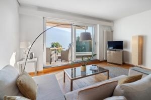 un soggiorno con un divano e un tavolo di VIEW Appartement including Parking ad Ascona
