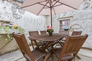 a wooden table with chairs and an umbrella at Stylish 2 Bed Home near Gatwick in Redhill